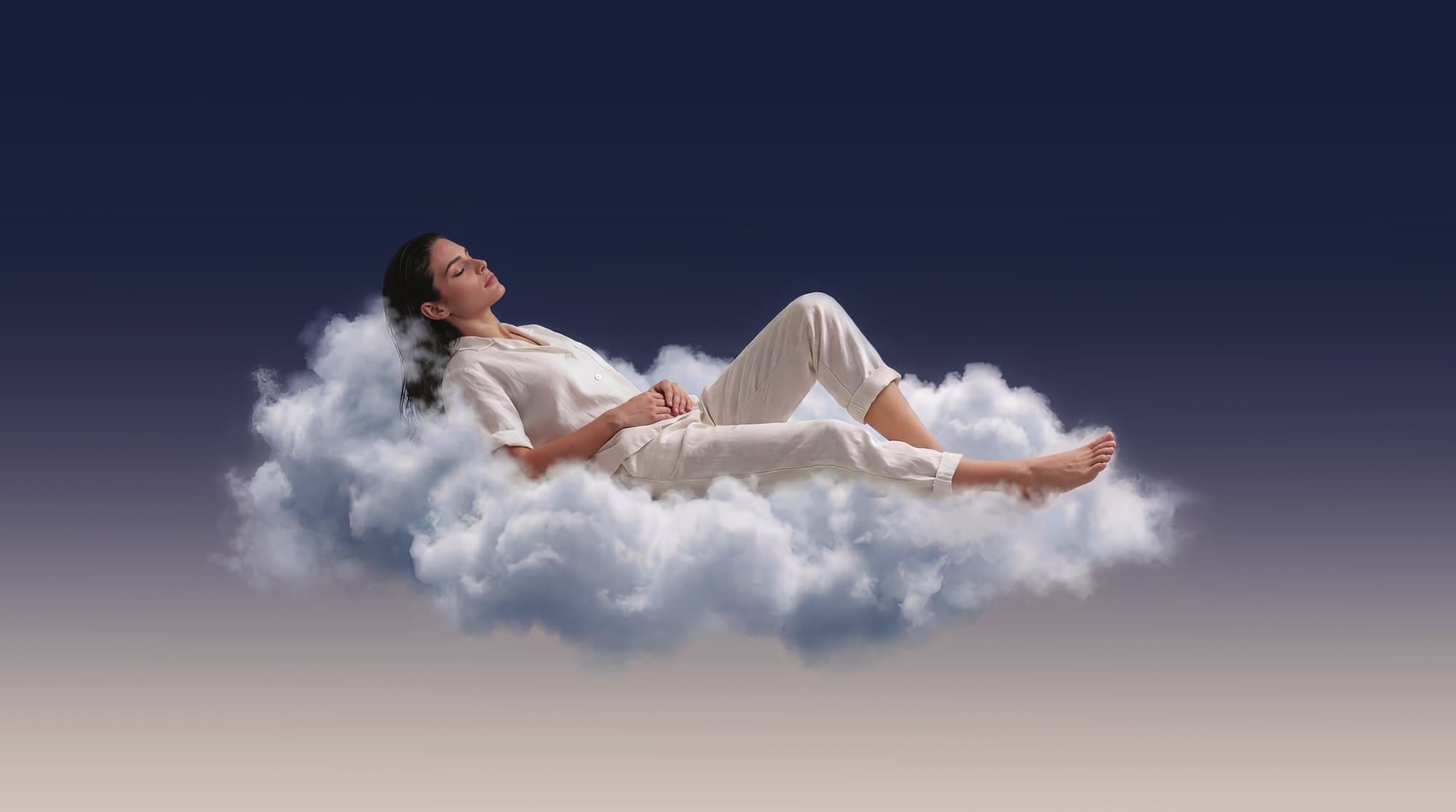 A woman resting on a cloud as night turns to dawn
